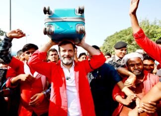 रेलवे स्टेशन पहुंच कुली के अवतार में नजर आए राहुल गांधी, बैज लगा व लाल शर्ट पहन उठाया सामान राहुल बने कुली
