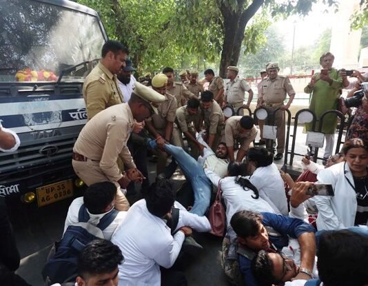 गांधी प्रतिमा के पास बॉन्डेड डॉक्टरों ने किया प्रदर्शन, पुलिस बस के आगे लेटीं प्रदर्शनकारी बॉन्डेड डॉक्टर